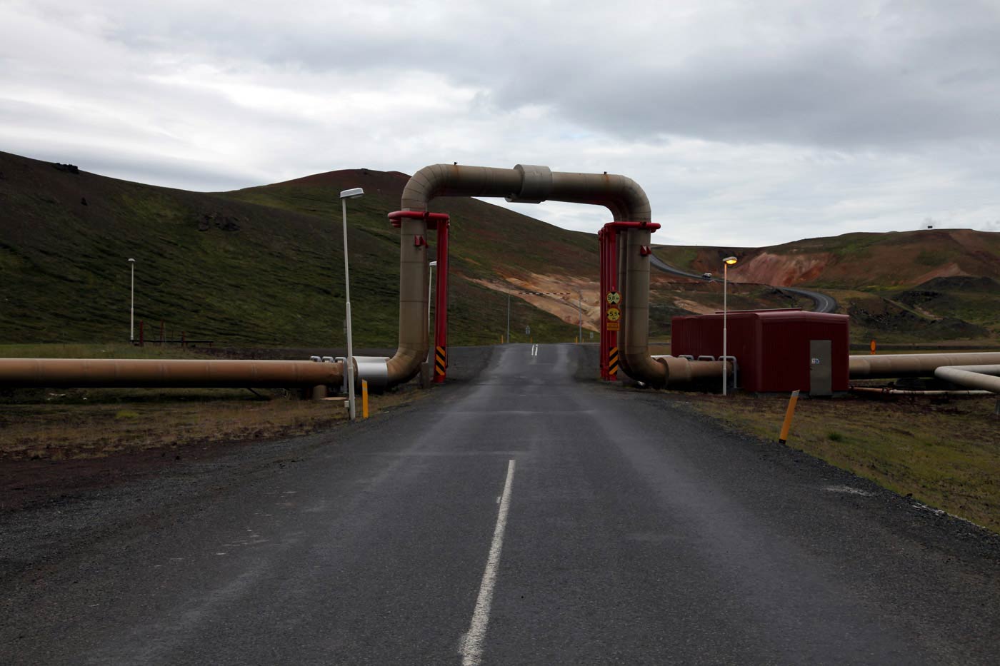 Pipes carrying geothermally heated water across the road at Krafla, Iceland